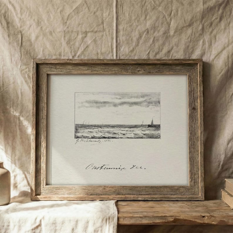 May include: A framed monochrome seascape print. The artwork shows a wavy ocean with sailboats under a cloudy sky. The frame is made of weathered wood, giving a rustic feel. The print is signed.