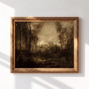 May include: A landscape painting in a decorative gold frame with a repeating leaf pattern. The artwork depicts a dark, moody forest scene with tall trees and a reflective body of water in shades of brown, black, and muted beige tones.