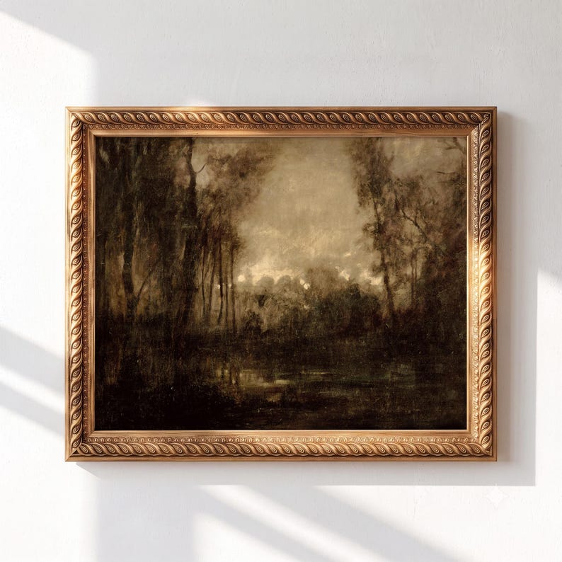 May include: A landscape painting in a decorative gold frame with a repeating leaf pattern. The artwork depicts a dark, moody forest scene with tall trees and a reflective body of water in shades of brown, black, and muted beige tones.