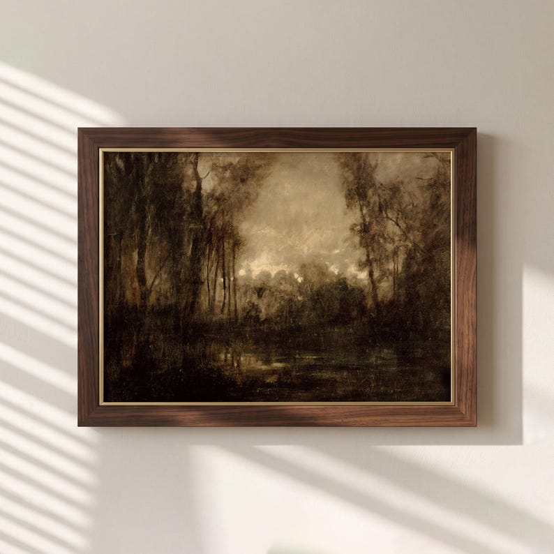 May include: A framed landscape painting featuring a dark, moody forest scene with tall trees and a reflective body of water. The artwork uses a monochromatic sepia and brown color palette, encased in a dark wood frame with a thin gold inner border.