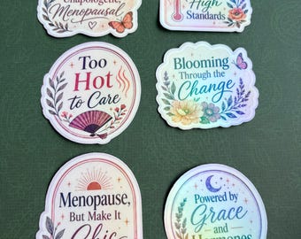 May include: Six decorative stickers featuring floral and celestial motifs with text including Unbothered, Unapologetic, Menopausal, Hot Flashes & High Standards, Too Hot to Care, Blooming Through the Change, Menopause, But Make It Chic, and Powered by Grace and Hormones.