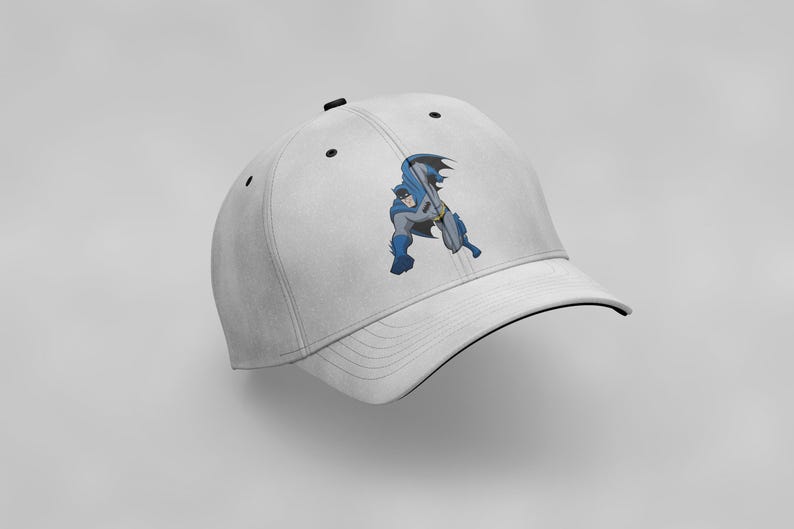 K&ouml;nnte beinhalten: Wei&szlig;e Baseballkappe mit schwarzem Schirm und einem Comicbild von Batman in einem blau-grauen Kost&uuml;m.
