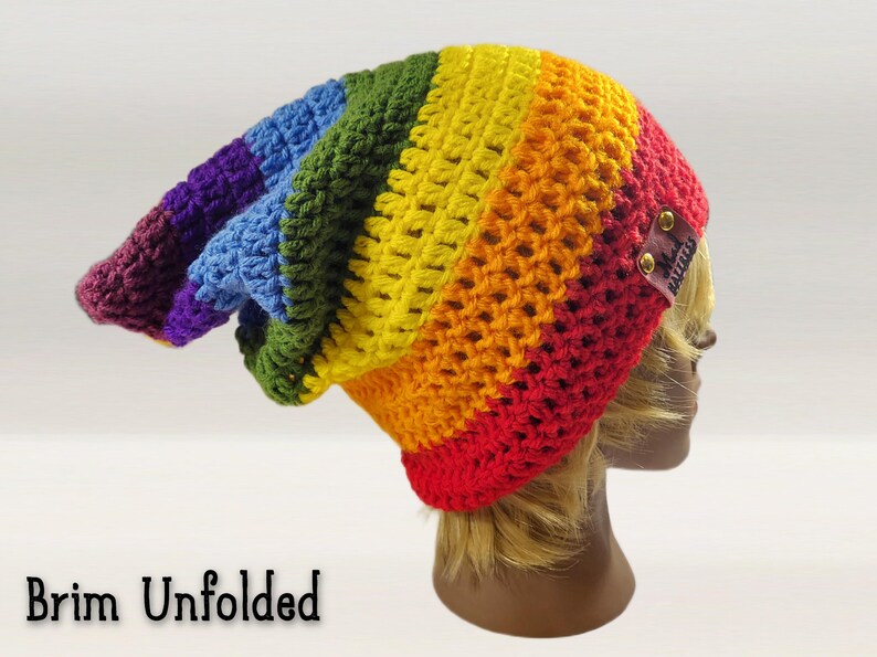 Image reads "brim unfolded" - this fun pointed beanie is shown from the side with its brim unfolded showing its long length and pixie shaped back part. Beanie can be adjusted to any height, slouch length, you can change the colors, the style, even change the brim type from foldable to ribbed.  make this beanie fit your style!  make general customizations free of charge!  Add pom poms, hand made embroidered patches, tassels, buttons, add your name, anything you want for your very own custom hat.
