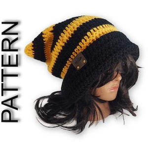 May include: Black and yellow striped crochet beanie with a brown leather patch. The beanie is slouchy and has a long tail.