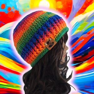 May include: A colorful, hand-crocheted beanie hat in a rainbow of colors, including orange, green, blue, and yellow. The hat has a textured stitch pattern and a small, brown leather tag with a logo. The hat is shown on a mannequin head.