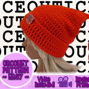 Può includere: Un berretto all'uncinetto arancione brillante con un motivo a punto strutturato e una lunga nappa. Il cappello presenta una piccola etichetta in pelle ed è mostrato su una persona con i capelli biondi. Il testo sull'immagine include "CROCHET PATTERN ~ EASY ~ Video Included! Beginner Friendly."