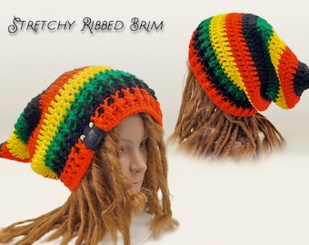 Puede incluir: Un gorro de ganchillo con rayas horizontales en negro, amarillo, verde y naranja. El gorro incluye una etiqueta rectangular negra en el lateral y el texto Stretchy Ribbed Brim. El diseño tiene un ajuste holgado y una textura acanalada.