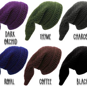 May include: Six crocheted elf hats in shades of dark orchid, thyme, charcoal, royal blue, coffee, and black. Each hat features a long, pointed end. The colour names are printed below each hat in a handwritten style font.