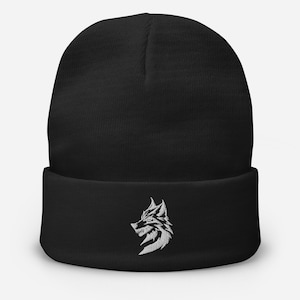 Puede incluir: Gorro negro con un diseño de cabeza de lobo bordado en blanco.