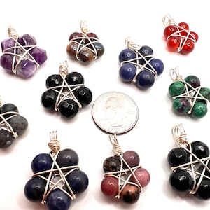 May include: Ten wire-wrapped pentacle pendants with various gemstone beads. The pendants feature a five-pointed star design with a wire frame and are made with different colored gemstones, including amethyst, black onyx, carnelian, green aventurine, and blue lapis lazuli.