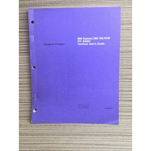 May include: A purple IBM System/360 OS/DOS ITF: BASIC Terminal User's Guide manual. The front cover features the text Program Product, the title, and the IBM logo. The document has three punched holes along the left side for binder storage.