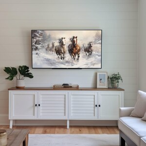 Pu&ograve; includere: Una consolle multimediale bianca con quattro ante e un piano in legno. Un televisore &egrave; montato sopra la consolle, che mostra un dipinto di cavalli che corrono attraverso un paesaggio innevato. Un piccolo quadro incorniciato &egrave; appeso al muro a destra del televisore.