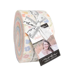 May include: A rolled bundle of pastel fabric strips, featuring floral patterns in pink, blue, and yellow on a cream background. The bundle is tied with a ribbon and a tag that reads "Pastel" and "moda FABRICS + SUPPLIES".