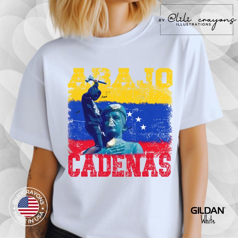 May include: White t-shirt with a graphic design featuring a person holding a hammer and the text "ABAJO CADENAS" in red, yellow, and blue. The graphic also includes a stylized image of the Venezuelan flag.