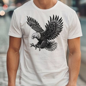 May include: A white t-shirt with a black and white illustration of an eagle in flight.