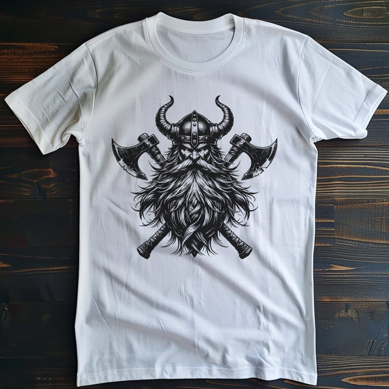 May include: White t-shirt with a black and white graphic of a Viking warrior with a horned helmet and crossed axes.
