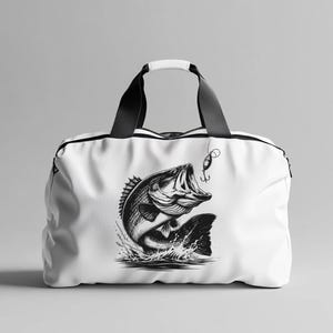 K&ouml;nnte beinhalten: Wei&szlig;e Canvas-Sporttasche mit einem schwarzen Barsch, der aus dem Wasser springt, und einem K&ouml;der dar&uuml;ber. Der Fisch ist in Schwarzwei&szlig; dargestellt.