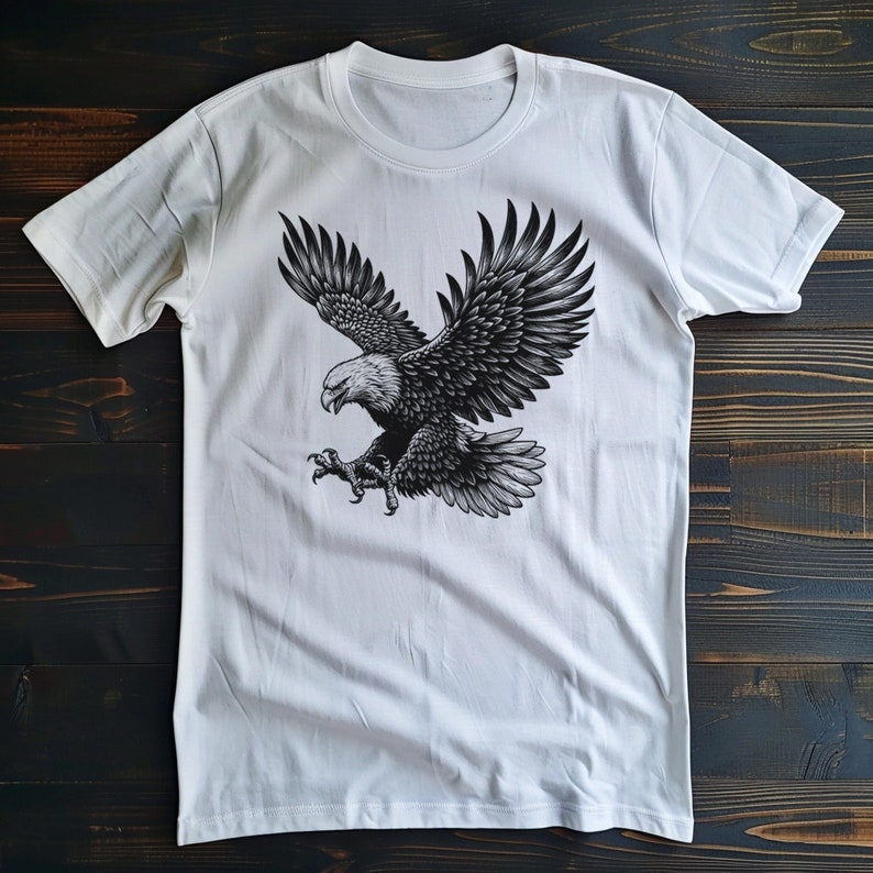 May include: White t-shirt with a black and white graphic print of an eagle in flight.