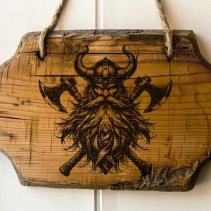 May include: A wooden sign with a Viking warrior design. The warrior is wearing a horned helmet and has a long beard. Two axes are crossed behind the warrior.