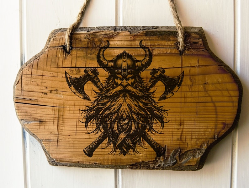 May include: A wooden sign with a Viking warrior design. The warrior is wearing a horned helmet and has a long beard. Two axes are crossed behind the warrior.