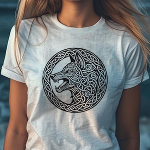 May include: White t-shirt with a black and white graphic of a wolf's head inside a Celtic knot design.