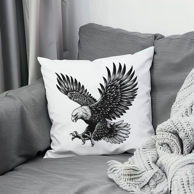 May include: A white throw pillow with a black and white illustration of an eagle in flight. The eagle is depicted with its wings spread wide and its talons extended.