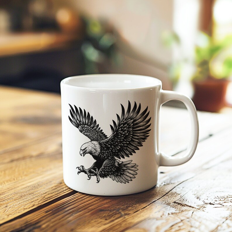 May include: White ceramic mug with a black and white illustration of an eagle in flight. The eagle is depicted with its wings spread wide and its talons extended.