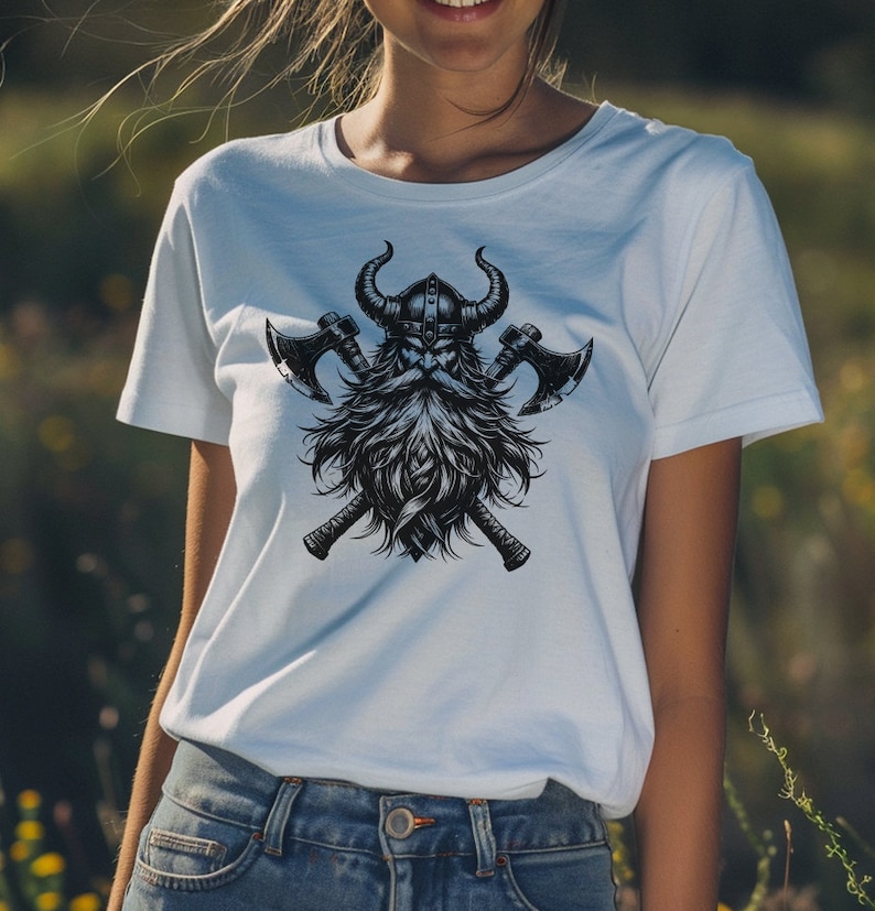 May include: White t-shirt with a black and white graphic print of a Viking warrior with a horned helmet and crossed axes.