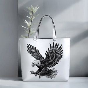 May include: White tote bag with a black and white illustration of an eagle with its wings spread.