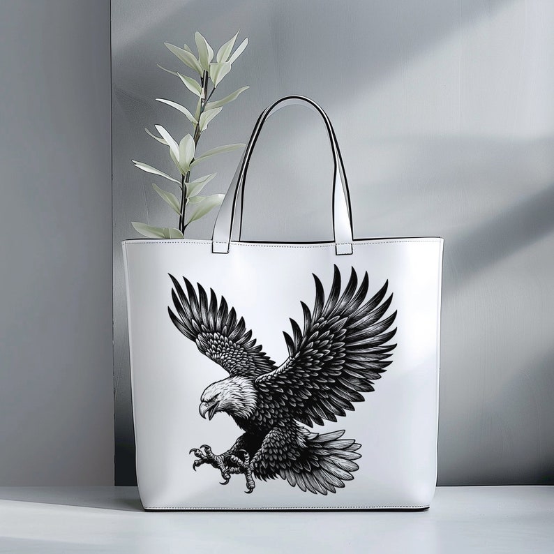 May include: White tote bag with a black and white illustration of an eagle with its wings spread.