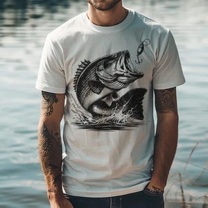 K&ouml;nnte beinhalten: Wei&szlig;es T-Shirt mit einem schwarz-wei&szlig;en Motiv eines Gro&szlig;maulbarsches, der mit einem Angelk&ouml;der im Maul aus dem Wasser springt.