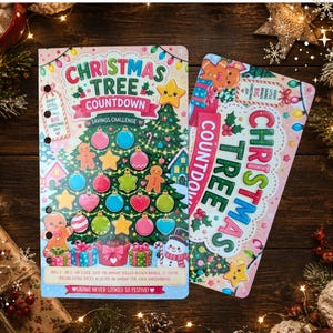 May include: Two Christmas Tree Countdown savings challenge books. The covers are pink with a Christmas tree design, ornaments, gingerbread men, and the text "Christmas Tree Countdown Savings Challenge". One book is open, showing the interior pages.