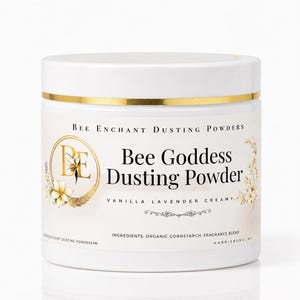May include: A white jar of Bee Goddess Dusting Powder with a gold band around the lid. The label features the text "Bee Goddess Dusting Powder" and "Vanilla Lavender Creamy". The jar also has a logo of a bee.