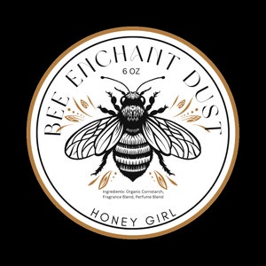 May include: A circular label with a gold border and the words "BEE ENCHANT DUST" in a circular pattern. A detailed black and white bee graphic is in the center. The label also includes the text "6 OZ", "HONEY GIRL", and ingredient information.