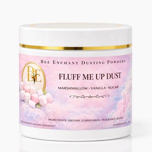 May include: A white jar with a gold band and lid, labeled "Bee Enchant Dusting Powders." The label features the text "Fluff Me Up Dust" and lists marshmallow, vanilla, and sugar as ingredients. A bee logo is visible.