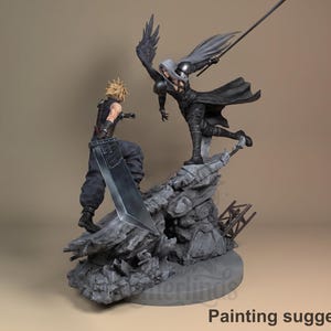 Può includere: Statuetta dettagliata raffigurante una scena di battaglia con due personaggi. Uno ha capelli biondi a spillo e una grande spada, mentre l'altro ha lunghi capelli argentati e un'ala nera. La base è un terreno roccioso.