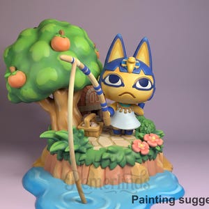 Puede incluir: Figura de un personaje felino amarillo con orejas y marcas azules, sosteniendo una caña de pescar. La figura está colocada en una pequeña isla con un árbol que lleva fruta naranja, flores y una fuente de agua. El texto "Painting suggestion" está en la parte inferior.