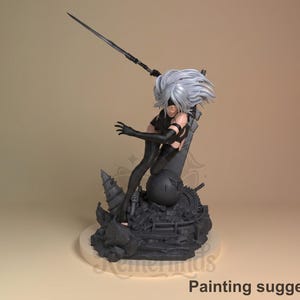 Può includere: Una statuina nera di un personaggio con capelli bianchi, una benda e una spada. La figura è posizionata dinamicamente sopra una base dettagliata con elementi meccanici e architettonici. Il testo "Painting suggestion" è in basso.