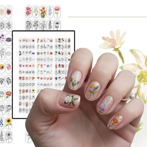 Puede incluir: Una colecci&oacute;n de pegatinas florales para u&ntilde;as con diversos dise&ntilde;os bot&aacute;nicos en color y en blanco y negro. Las pegatinas est&aacute;n dispuestas en cuadr&iacute;culas sobre l&aacute;minas, con motivos florales individuales aplicados sobre las u&ntilde;as.