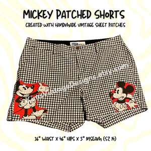 May include: Black and white gingham shorts featuring two Mickey Mouse patches on the front. The text reads MICKEY PATCHED SHORTS, CREATED WITH HANDMADE VINTAGE SHEET PATCHES, and 36" WAIST X 46" HIPS X 5" INSEAM (SZ 14).