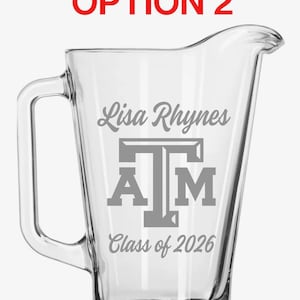 May include: Clear glass jug with a handle and a pouring spout. The jug is engraved with the name "Lisa Rhynes", the letters "A T M", and "Class of 2026". The text "FRONT OPTION 2" is in red at the top.