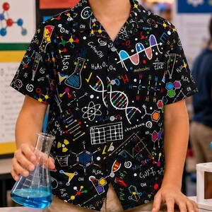May include: A short-sleeve button-down shirt with a black background featuring a colorful science-themed print of chemical formulas, DNA strands, and laboratory glassware. The shirt has a classic collar and a button-front closure.
