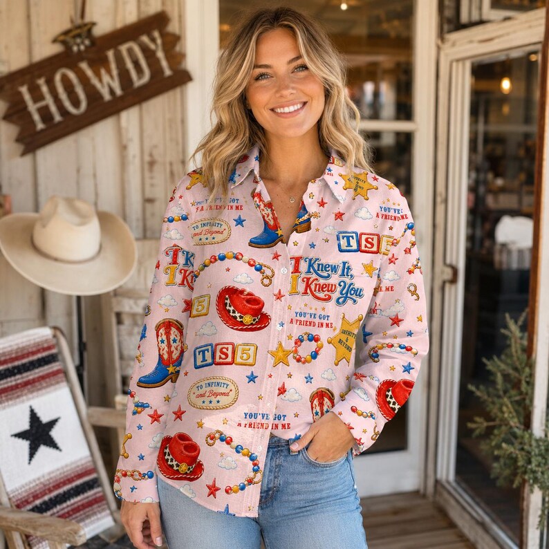 May include: A light pink long-sleeve button-down shirt featuring a repeating pattern of red and blue cowboy boots, red cowboy hats, yellow sheriff stars, and text including "I Knew It," "TS5," and "You've Got a Friend in Me" with blue jeans.