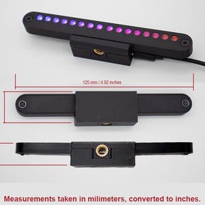 May include: A black rectangular LED light bar with a row of purple and red lights. The device features a central mounting block with a threaded hole. Dimensions are 4.92 inches long, 0.86 inches wide, and 0.64 inches deep as indicated by text.