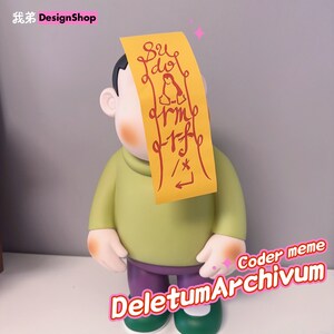 May include: A green and purple cartoon figurine with a yellow sticky note on its face. The sticky note has red writing that says "sudo rm -rf / *"