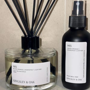 May include: A clear glass reed diffuser with black reeds and a black cap, alongside a black spray bottle. Both have white labels with the text "HIS BLOOD ORANGE | GRAPEFRUIT | LEATHER" and "KINGSLEY & OAK". The diffuser is 200ml, and the spray is 100ml.