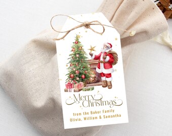 Könnte beinhalten: Ein Weihnachtsgeschenkanhänger mit einer Aquarellillustration von Santa Claus, einem geschmückten Weihnachtsbaum und einem Kamin. Der Anhänger trägt die Aufschrift "Merry Christmas" und enthält einen Familiennamen. Der Anhänger ist mit Bindfaden gebunden.