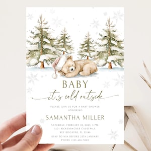 May include: Baby shower invitation with a watercolour illustration of a sleeping teddy bear in a snowy landscape with pine trees and snowflakes. The text reads "Baby it's cold outside" and includes event details.