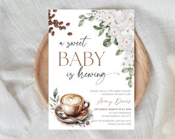 Könnte beinhalten: Eine weiße Babyparty-Einladung mit einer Kaffeetasse und einem Blumenmuster. Der Text lautet "a sweet baby is brewing".