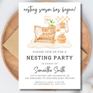 May include: A white card with a watercolor illustration of a crib and other baby items. The text on the card reads "Nesting Season Has Begun!" and "Please Join Us For A Nesting Party In Honor Of Samantha Smith Let's Gather And Celebrate As She Prepares To Welcome Baby Smith#2 March 13, 2022 2:00 PM 123 Anywhere St, Any City"